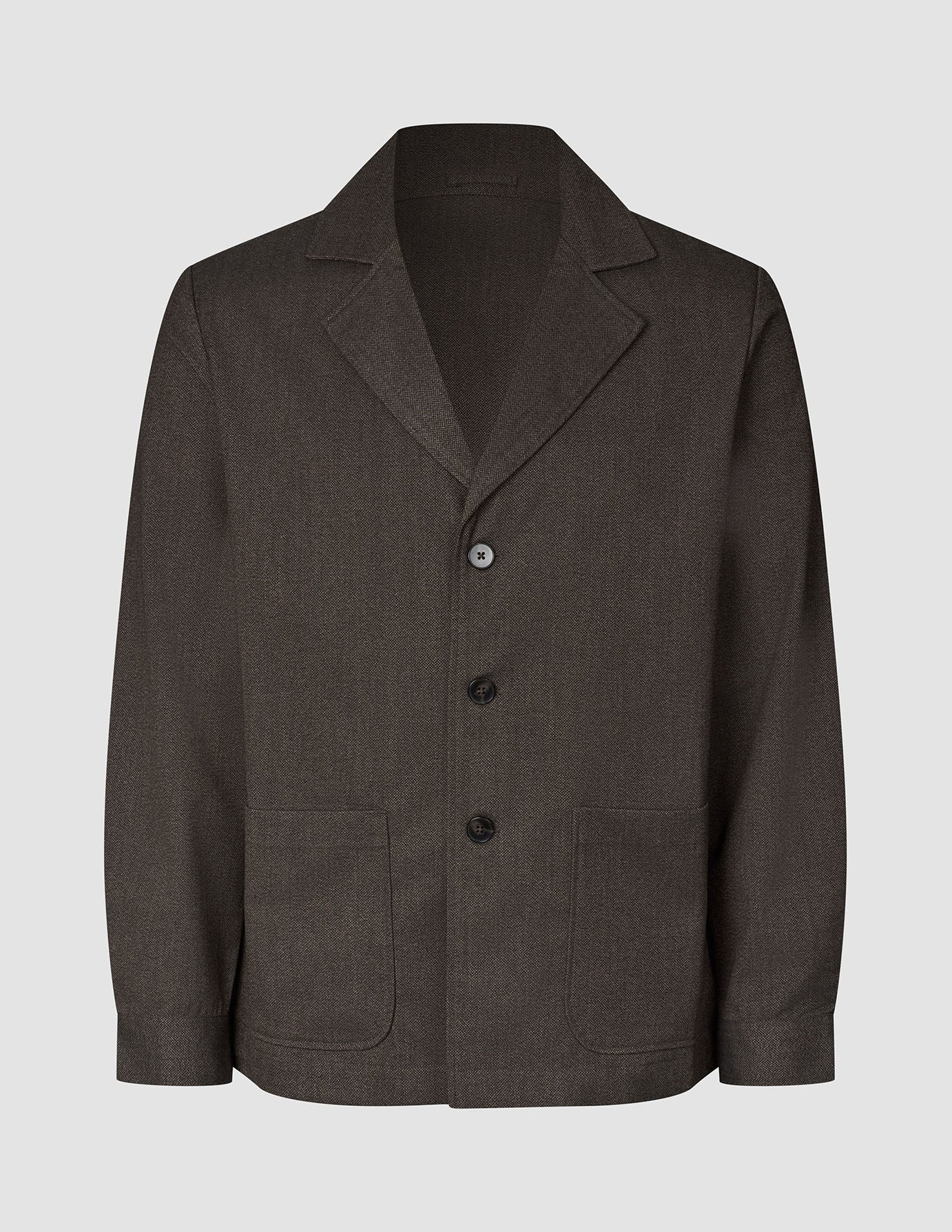 Atelier-Overshirt aus dunkelbraunem Broken-Twill mit gekerbtem Kragen, drei Knöpfen, zwei aufgesetzten Vordertaschen und einer Silhouette im Blazer-Stil.